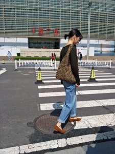 Dettaglio borsa shopper in tela con stampa leopardata indossata in stile street fashion