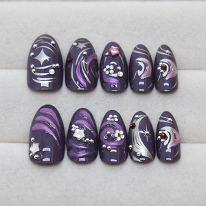 Dark purple pearlescent press-on nails with sparkling rhinestones and star art