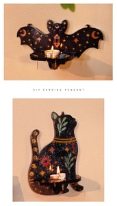 Close-up of black cat and bat wall hanging candle holders with celestial gold patterns