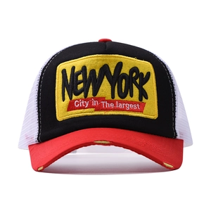 Detail of New York patch embroidery on tricolor mesh trucker hat with breathable design