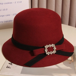 Détail du chapeau cloche en laine bordeaux avec ruban noir et boucle en strass