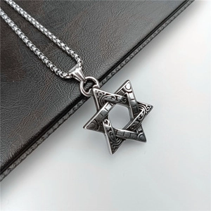Close-up of vintage silver hexagram pendant on a square pearl chain over leather