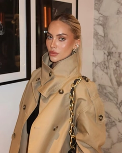 Detail of double-breasted beige trench coat with stand collar and waist belt