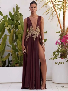 Close-up of golden lace embroidery on burgundy deep V-neck evening gown with high slit