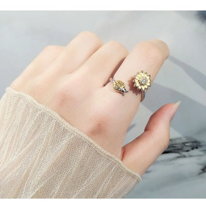 Dettaglio dell'anello rotante con girasole e coccinella in argento indossato al dito