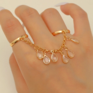 Gold double-finger ring featuring delicate chains and pink teardrop crystal charms