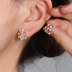 Elegant gold flower cluster earrings with sparkling zircons worn for a luxury look