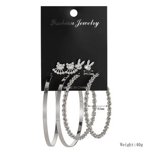 Detail view of 9-pair geometric earring set including silver hoops and crystal studs