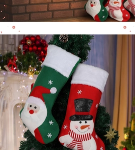 Detail of hanging Christmas stockings with Santa and snowman appliques on a tree