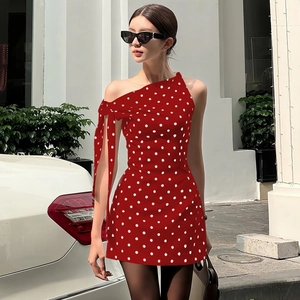 Detail of red polka dot dress featuring a stylish one-shoulder bow tie and slim fit cut