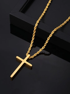 Polished gold cross pendant with twisted rope chain displayed on a black jewelry box