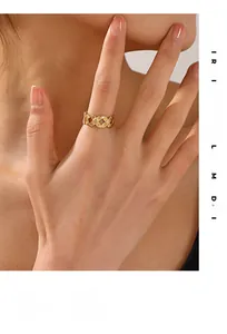 Close-up of golden braided wide ring with textured weave pattern on a model's finger