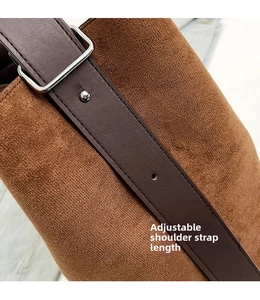 Macro detail of adjustable silver buckle on brown suede bag with leather strap