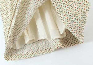 Detail van de bloemenjurk zoom met gladde beige voering en fijne rode bloemenpatronen