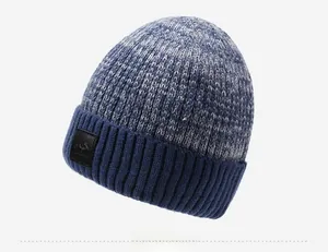 Dettaglio della trama a maglia e toppa in pelle su berretto invernale blu e grigio
