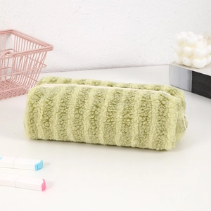 Macro shot of green plush pencil case with textured sherpa fabric and metal zipper