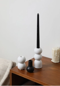 Macro shot of matte ceramic candle holders in geometric shapes with smooth textures
