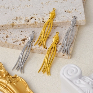 Detailed view of silver and gold octopus charms on a textured stone surface for jewelry
