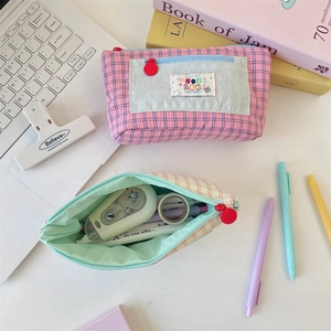 Detail of checkered pencil case showing spacious interior storage for various stationery
