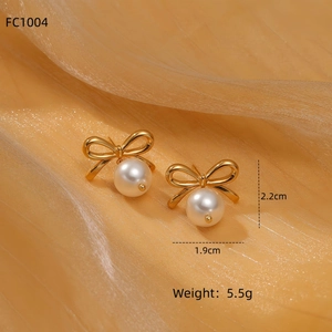 Close-up of pearl bow earrings in gold finish on silk, size 1.9cm by 2.2cm