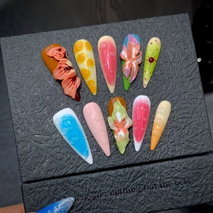 Detailed macro view of 3D embossed floral patterns and water drops on stiletto press-on nails