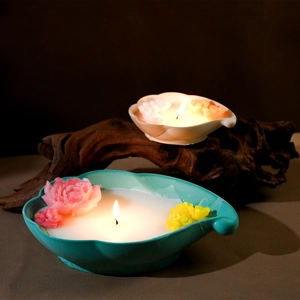 Detail von floralen Keramik-Kerzenschalen mit handgefertigten Wachsblumendekorationen