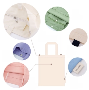 Detail view of reinforced stitching, zipper pocket and magnetic buckle on canvas tote