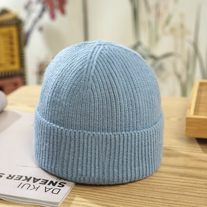 Close-up of light blue knit beanie showing thick ribbed texture and folded cuff detail