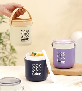 Close-up of portable stainless steel soup cups with lids and ergonomic white handles