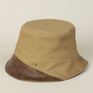 Detail view of khaki cotton bucket hat with premium brown leather brim and gold logo