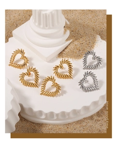 Detail of gold and silver hollow heart earrings with textured edges on display