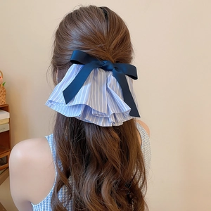 Detail einer blau gestreiften Stoffschleife am Pferdeschwanz für elegante Frisuren