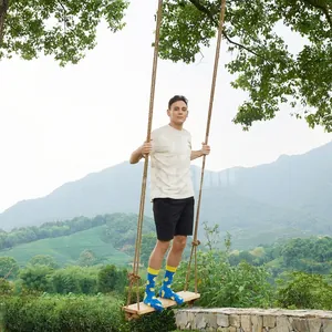 Outdoor shot of blue socks with yellow duck print and ribbed cuffs on a swing