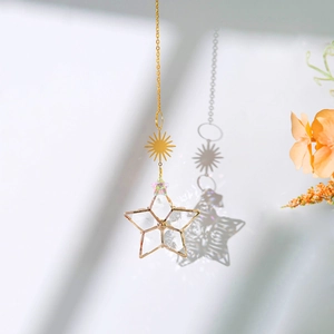 Golden sun and 3D glass star metal pendant casting artistic shadows on a wall