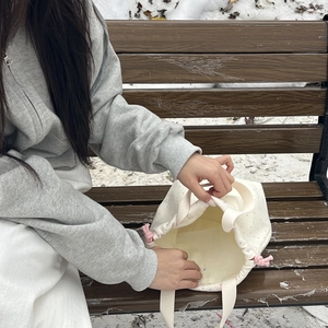 Detailed interior of a beige polka dot canvas bucket bag with pink drawstring handles