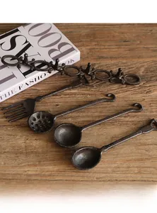 Dettaglio di ganci da parete in ghisa industriale con design di utensili da cucina