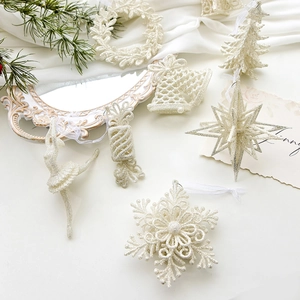 Sparkling champagne gold Christmas ornaments set with snowflake and star on white silk