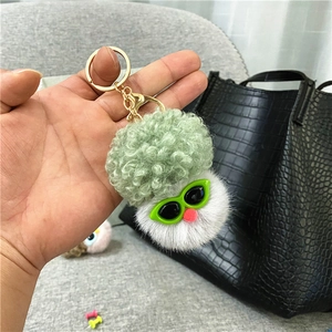 Détail d'un porte-clés en peluche chou-fleur avec lunettes vertes et fermoir doré