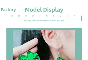 Close-up of model wearing green acrylic frog-shaped drop earrings with leaf base design