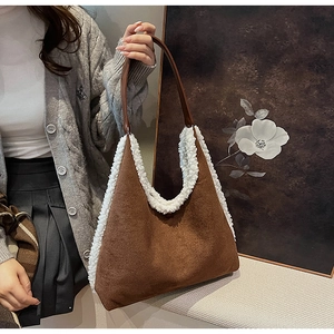Detail of brown faux suede tote bag with white plush trim and V-shaped opening design