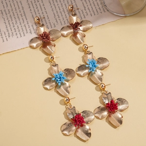 Vintage metal flower drop earrings with colorful centers on retro book background