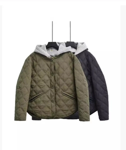 Detail of hooded quilted jacket featuring diamond lattice stitching and button closure