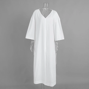 Detailed view of white cotton V-neck dress featuring loose sleeves and side slit design