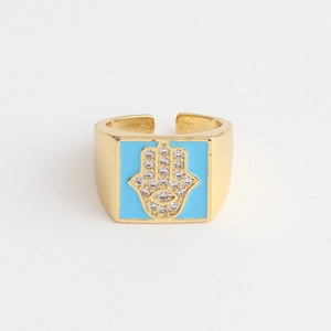 Detailed view of gold-plated Hamsa ring with blue enamel and cubic zirconia accents