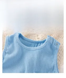 Detail of light blue baby bodysuit featuring ribbed cotton fabric and shoulder buttons