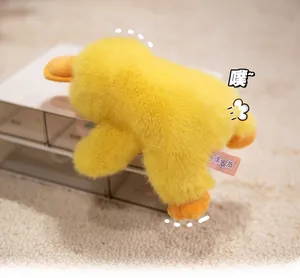 Close-up of yellow plush duck toy featuring soft long fur and pink brand fabric label
