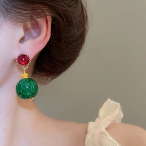 Detail view of retro resin round earrings with vibrant red and green beads for a vintage look