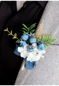 Close-up of blue berry and white hydrangea boutonniere on a dark suit lapel