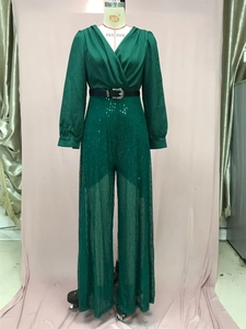 Detail of dark green sequined jumpsuit with V-neck wrap top and sparkling waist belt