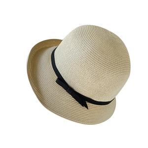 Women's woven straw sun hat with black bow ribbon detail on a white background